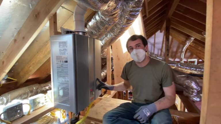Alex Pell in the attic of a Piedmont addition next to the tankless water heater, where keeping plumbing in the crawl space would have avoided water hammer