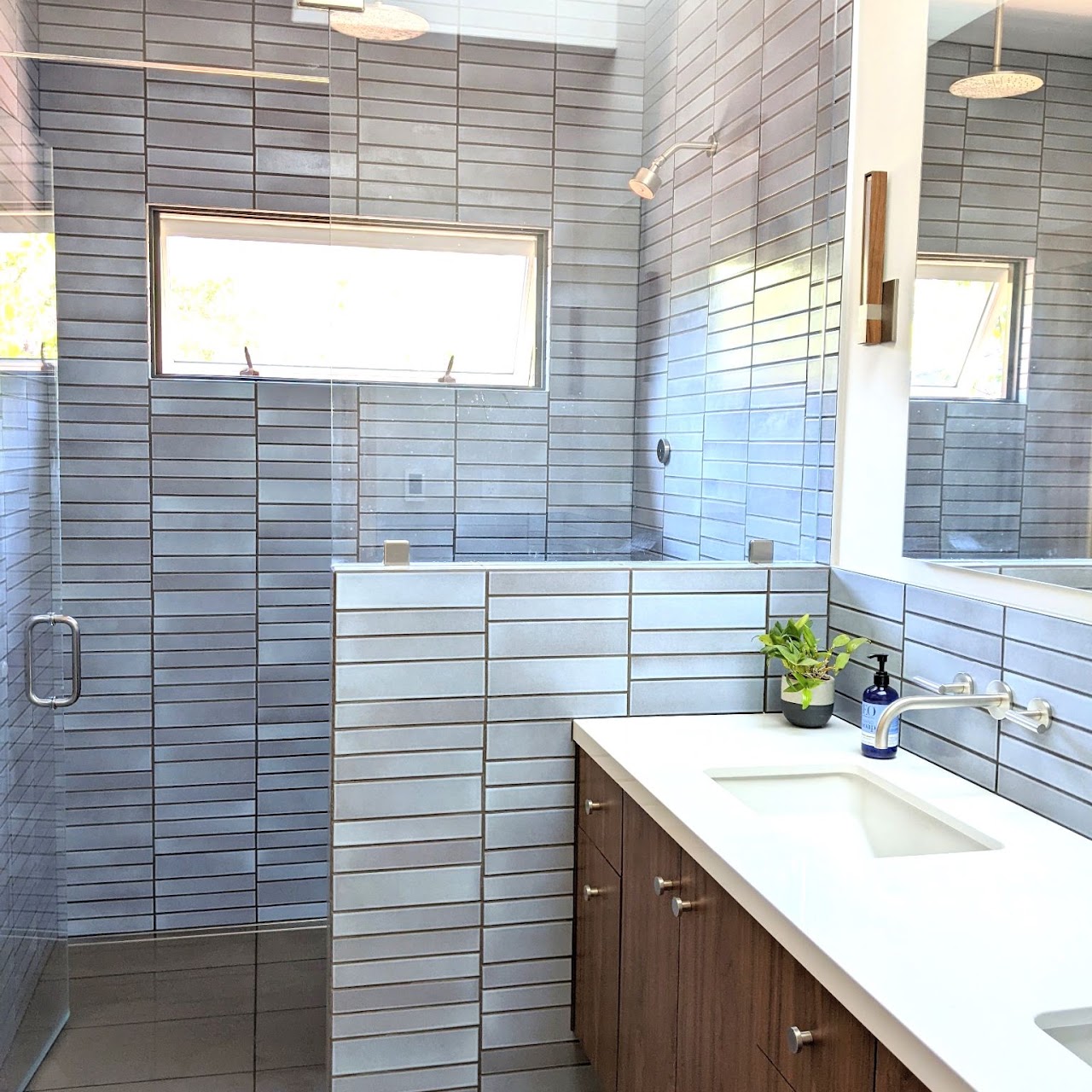 Piedmont addition bathroom in handmade blue tile, with full tiles around the window, across the pony wall and shower, and behind the vanity